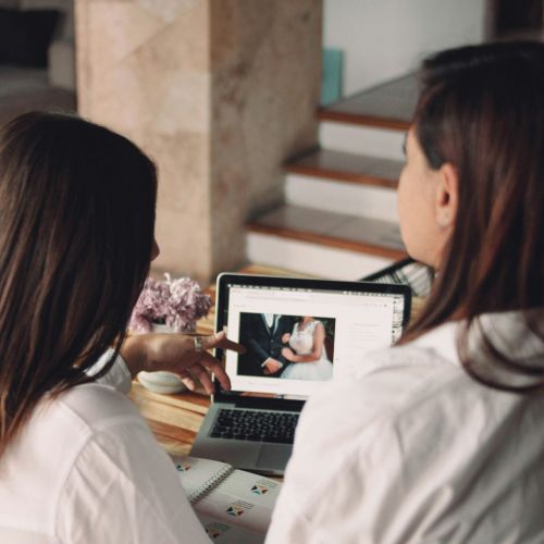 A couple is having online wedding, sitting in front of laptop