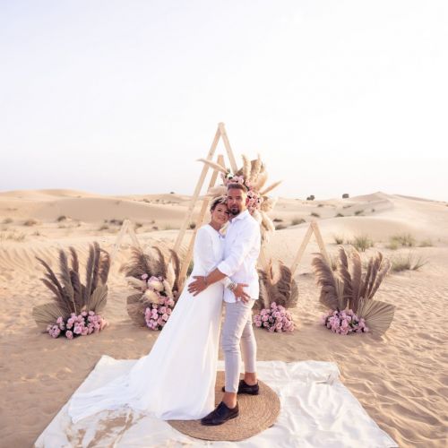 A couple standing in the desert on their wedding day