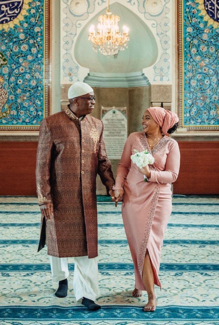 A couple standing for photoshoot in the mosque for their nikah ceremony