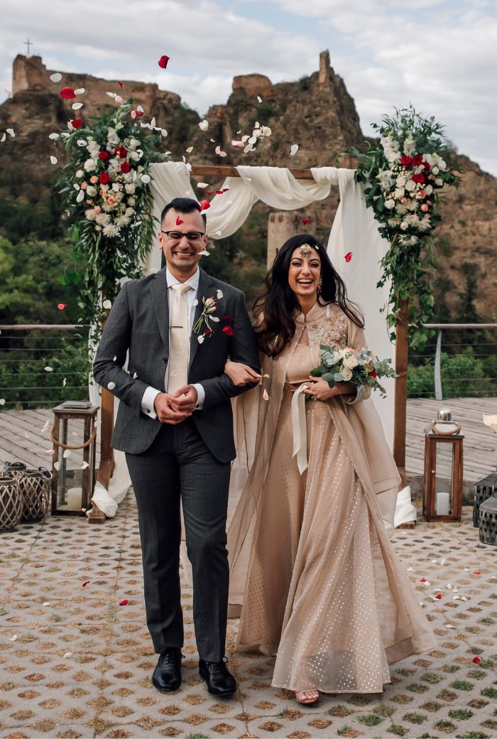 A couple standing for photoshoot at their wedding ceremony